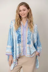 Camisa de seda estampada, modelo tipo pañuelo en tonos celestes y violeta, con mangas amplias y cierre frontal con botones.