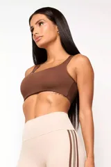 Top deportivo de entrenamiento con escote redondeado y espalda tipo nadador, confeccionado en poliamida tecnológica de alto rendimiento. Cuenta con forro interno y abertura para colocar almohadillas.