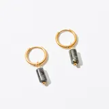 Aros dorados tipo argolla con dije cilíndrico de piedra gris veteada.