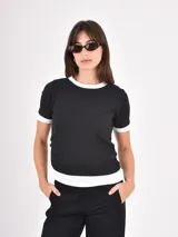 Remera de algodón en color negro con detalles en blanco en el cuello, mangas y ruedo. Presenta un diseño de estilo ringer con terminaciones acanaladas.