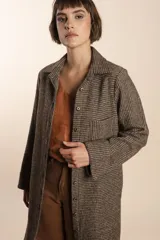 Camisa larga color beige con botones dorados y bolsillo plaque en la delantera. Confeccionada en lana fina sin teñir, diseñada exclusivamente por Don Baez. Hecha 100% en Uruguay.