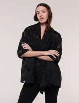Pashmina rectangular negra con textura, bordados florales en relieve de efecto deshilachado y ligera transparencia.