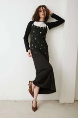 Vestido negro de tirantes finos con escote redondo y apliques redondos de nácar distribuidos por toda la prenda.