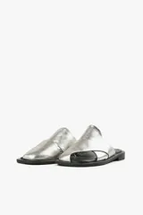 Sandalias planas de cuero color blanco hueso, con dos tiras anchas cruzadas en la parte superior y diseño minimalista.