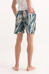 Short de baño con estampado de hojas tropicales en tonos verdes y detalles en naranja. Cuenta con cintura elástica con cordón ajustable.