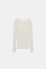 Camiseta de manga larga, cuello redondo, color blanco roto con estampado de lunares negros.