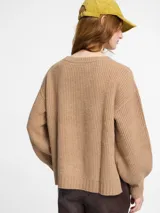 Sweater color camel de tejido de punto grueso, con cuello redondo y mangas largas con sisa caída.