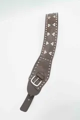 Cinturón ancho de cuero sintético color marrón, con diseño decorado con tachas metálicas plateadas y apliques circulares claros. Incluye una hebilla metálica plateada y cierre ajustable.
