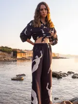 Pantalón palazzo negro con estampado de sirenas en color beige.