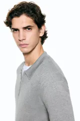 Remera polo de punto acanalado fino, con cuello clásico, medio cierre frontal y mangas cortas. Presenta un diseño entallado con bajo recto.