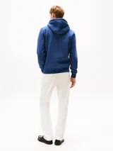 Buzo con capucha de tejido jaspeado azul, corte regular, con bolsillo canguro frontal y cordones blancos. Presenta el logo de Tommy Hilfiger bordado en el pecho.