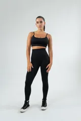 Conjunto deportivo celeste compuesto por un top con tirantes finos y calza larga de cintura alta.