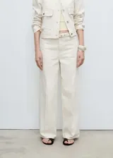 Pantalón jeans de corte wide leg en color crudo, con tiro medio, cierre frontal de cremallera y botón, cuatro bolsillos y trabillas en la cintura. Incluye un cinturón fino del mismo tejido con cierre de hebilla.