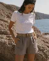 Short de lino color azul marino, de tiro alto, con bolsillos laterales y e incluye un cinto de rafia con hebilla redonda.