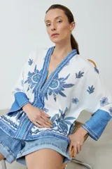 Kimono blanco con estampado floral azul, con mangas 3/4 y cierre frontal con cordón.