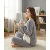 Conjunto de pijama de dos piezas confeccionado en tela de plush suave y abrigada. Incluye una remera de manga larga con diseño estampado de Totoro y pantalón largo a juego con puños en contraste.