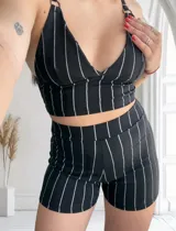 Short de tiro alto con diseño de rayas verticales plateadas sobre fondo negro, confeccionado en tela elástica.