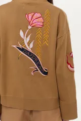Cardigan tejido de algodón color camel con cuello en V, cierre frontal de botones y bordados coloridos con motivos variados.