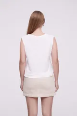 Musculosa blanca de algodón con detalle de puntilla en el ruedo.