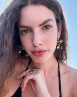 Aros colgantes de bronce dorado con diseño orgánico y perla de río natural en el extremo inferior.