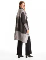 Cardigan largo tejido con diseño patchwork en tonos grises y negros. Presenta cuello con amplia solapa, diseño abierto sin botones y bolsillos delanteros amplios.