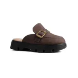 Zueco casual de estilo mule, color marrón, con capellada de cuero sintético y detalle de hebilla metálica dorada. Presenta una suela track de goma negra con plataforma dentada.