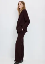 Pantalón de corte recto y tiro medio con diseño largo, trabillas para cinturón, dos bolsillos laterales y cierre oculto con botón, gancho y cremallera.