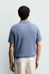 Polo de manga corta color azul con estructura piqué, cuello solapa y cierre frontal de dos botones. Cuenta con acabados en rib en cuello, mangas y ruedo.