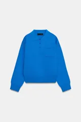 Jersey de punto con cuello tipo polo, manga larga con puños y cierre frontal con botones. Presenta un bolsillo de plastrón en el pecho y diseño de corte holgado.