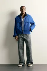 Cazadora cropped fit de algodón azul con efecto lavado, cuello solapa negro en contraste, cierre frontal con cremallera y bolsillos de plastrón con solapa en el pecho.
