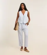Pantalón celeste de corte recto, confeccionado en tejido de lino y viscosa. Presenta cintura elástica con lazo ajustable, bolsillos laterales y pliegues frontales.