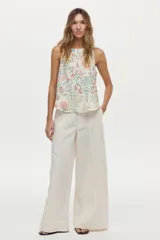 Musculosa de lino y viscosa, de color crudo con estampado multicolor de inspiración veraniega con flores, soles y motivos marinos. Presenta escote redondo y diseño sin mangas.