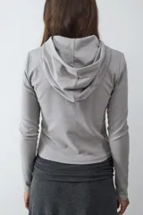 Camiseta de manga larga gris claro, confeccionada en tejido de punto, con capucha y cierre frontal de botones.