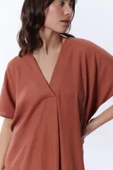 Vestido midi color canela de corte amplio, con escote en V y mangas cortas.