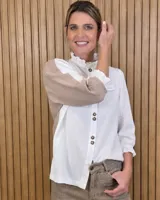 Camisa de diseño combinado en color blanco y tostado, con cuello alto con volados, mangas tres cuartos con puños elastizados con volados y cierre frontal con botones oscuros.