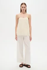 Musculosa de poliéster color marfil, con tirantes finos regulables, cuello cuadrado y diseño holgado, decorada con bordados de estrellas.