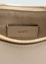 Bolso de mano y hombro de diseño semi-circular en color beige, con herrajes metálicos dorados, cierre superior de cremallera y correa ajustable desmontable.