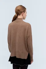 Polera tejida de punto confeccionada en lambswool color gris claro, con cuello alto y calce holgado.