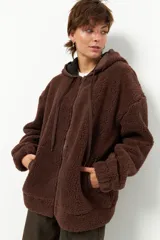Campera tipo canguro teddy negra con capucha y cierre. El forro es de felpa color verde militar.