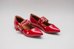 Chatitas rojas de charol con punta fina y dos tiras sobre el empeine con ojales metálicos y hebillas doradas.