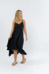 Vestido negro midi con tirantes finos y escote en V. Diseño fluido con bajo asimétrico.