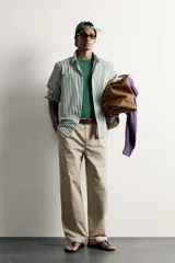 Camisa relaxed fit confeccionada en tejido de algodón, con diseño de rayas verticales en tonos azul y blanco, cuello con botones y manga larga.