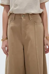 Pantalón jean verde militar, de tiro alto, corte ancho tipo wide leg y diseño de perneras amplias con costuras verticales decorativas.