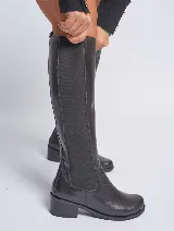 Bota de caña alta confeccionada en cuero vacuno negro, con panel elástico lateral para un ajuste cómodo y taco cuadrado de 4 cm. Cuenta con suela de caucho antideslizante y forro interior de cuero.