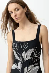 Malla enteriza negra con breteles anchos y estampado floral bordado en blanco y gris.