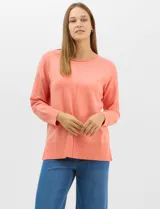 Buzo de tejido fino color amarillo, con cuello redondo, manga larga con puños acanalados y pespunte central vertical en el frente y la espalda. Presenta un ruedo ancho acanalado con tajos laterales.