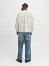 Sobrecamisa de manga larga confeccionada en sarga de algodón, con cuello camisero, cierre frontal de botones y un bolsillo en el pecho. Presenta un corte amplio y estructura versátil ideal para usar como capa ligera.