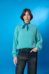 Sweater color beige de lana mohair y acrílico, con cuello redondo y mangas largas.