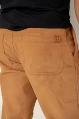 Pantalón de corte ancho confeccionado en tejido de pana suave, con diseño de pinzas en la cintura, cierre frontal con botón y bolsillos laterales.