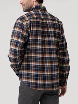 Camisa de manga larga con estampado de cuadros, confeccionada en algodón orgánico cepillado. Presenta cuello clásico, cierre frontal con botones de madera y dos bolsillos en el pecho.